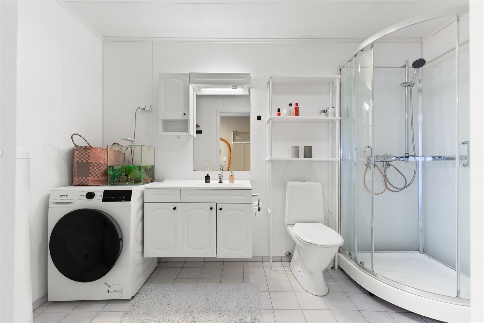 Boligens bad er fra byggeår og har våtromsplater på veggene og gulvet har fliser med elektriske varmekabler Galleribilde