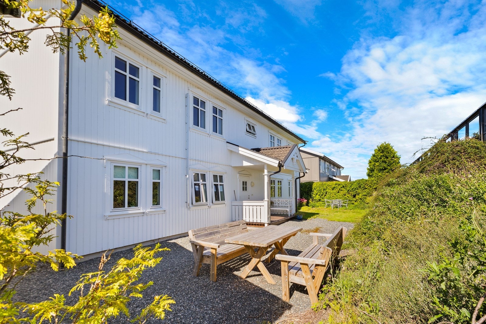 Pent opparbeidet, flat felles tomt med plen, beplantning og hekk. Asfaltert adkomstvei og gårdsplass gir enkel og praktisk tilkomst Galleribilde