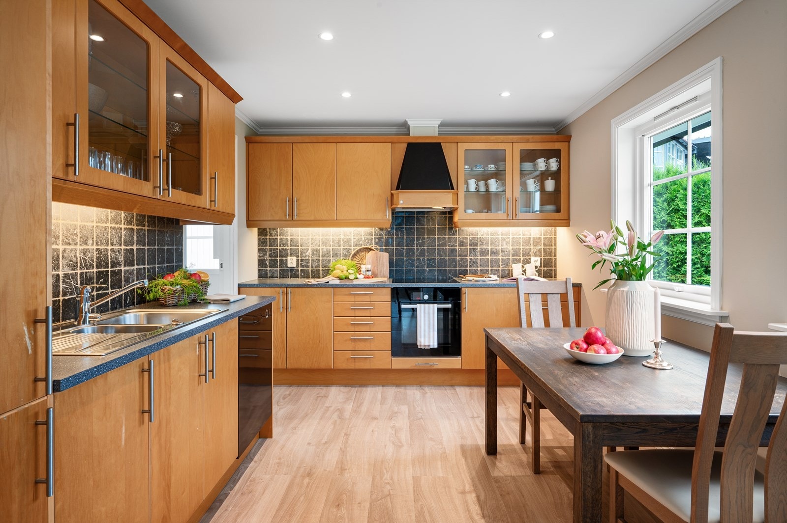 - Kjøkkeninnredning med honningtonet slette bjørkefronter, benkeplate i laminat og marmorfliser over benkeplate - Galleribilde