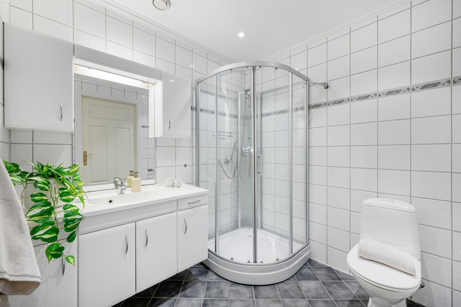 - Badet er innredet med servant med møblement/speil og belysning, toalett og dusjkabinett - Galleribilde