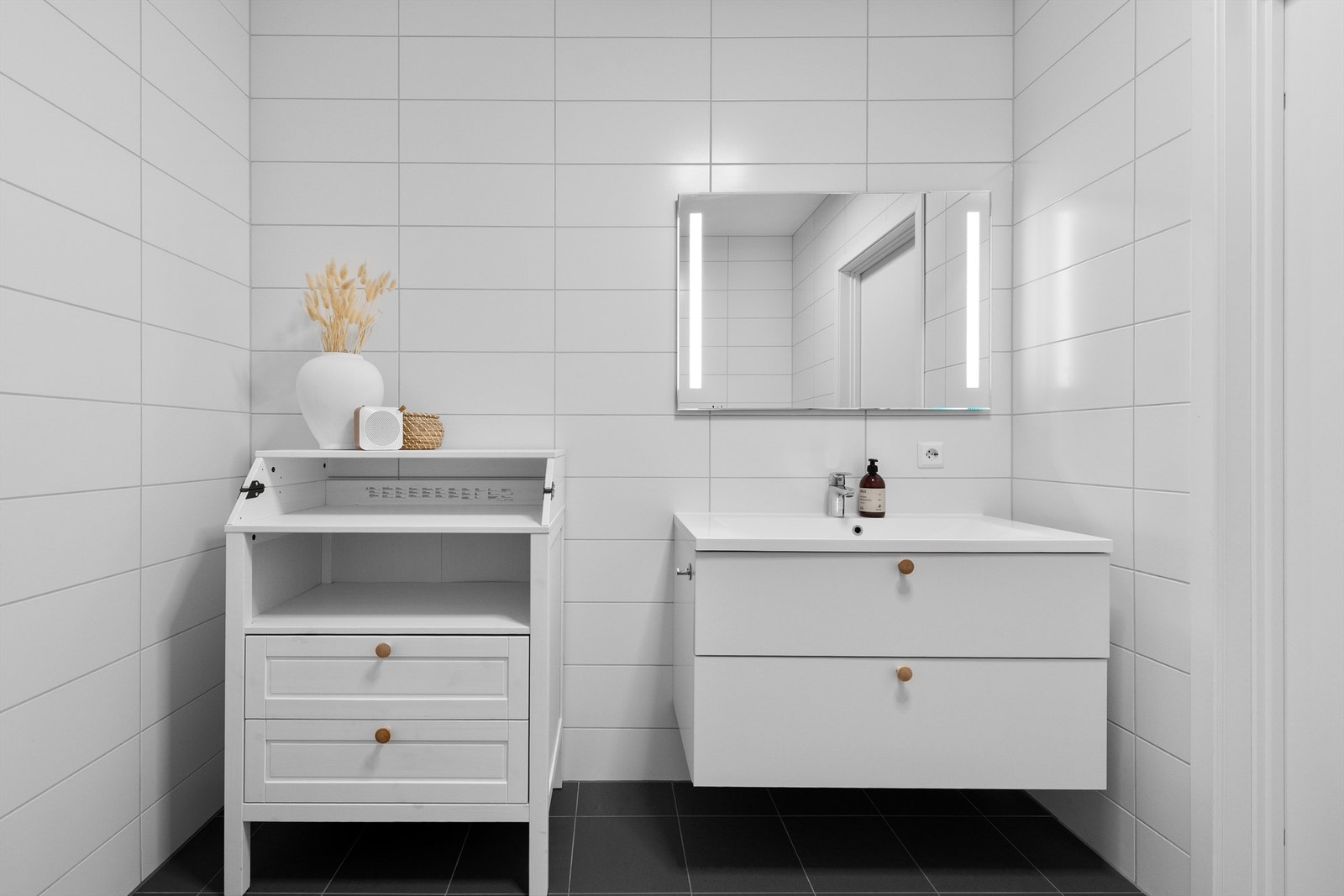 Baderomsinnredning med ovenpåliggende servant og speil med overlys og stikkontakt over servant Galleribilde