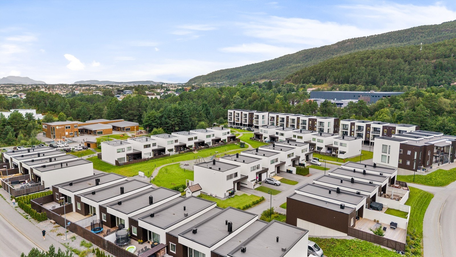 Dronebilde over boligområdet på Flisnesringen Leiligheten er liggende i blokken lengst bak mot vest Galleribilde