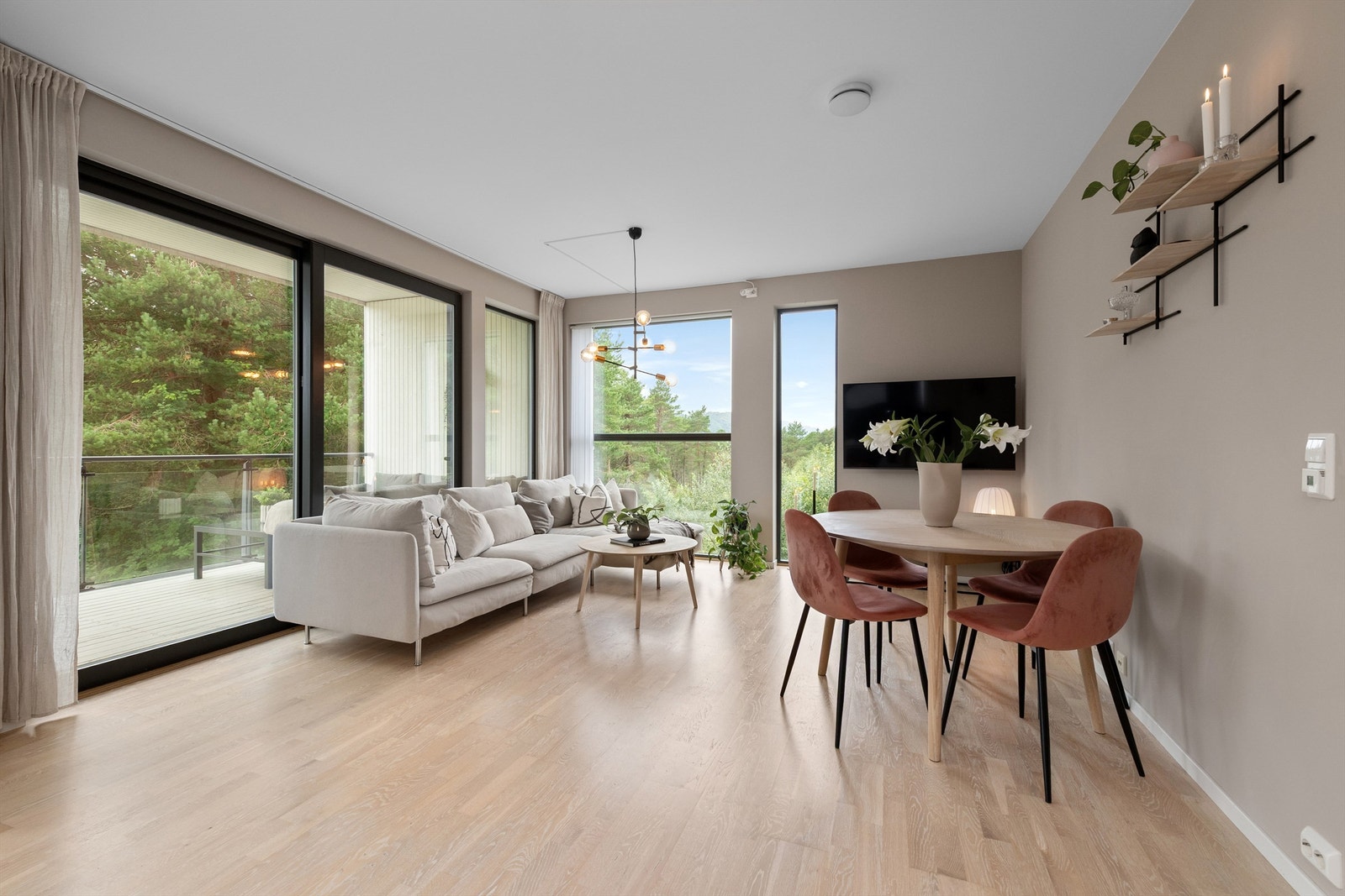 Stuen har lyse tiltalende overflater og godt med lysinnslipp fra store vindusflater Galleribilde