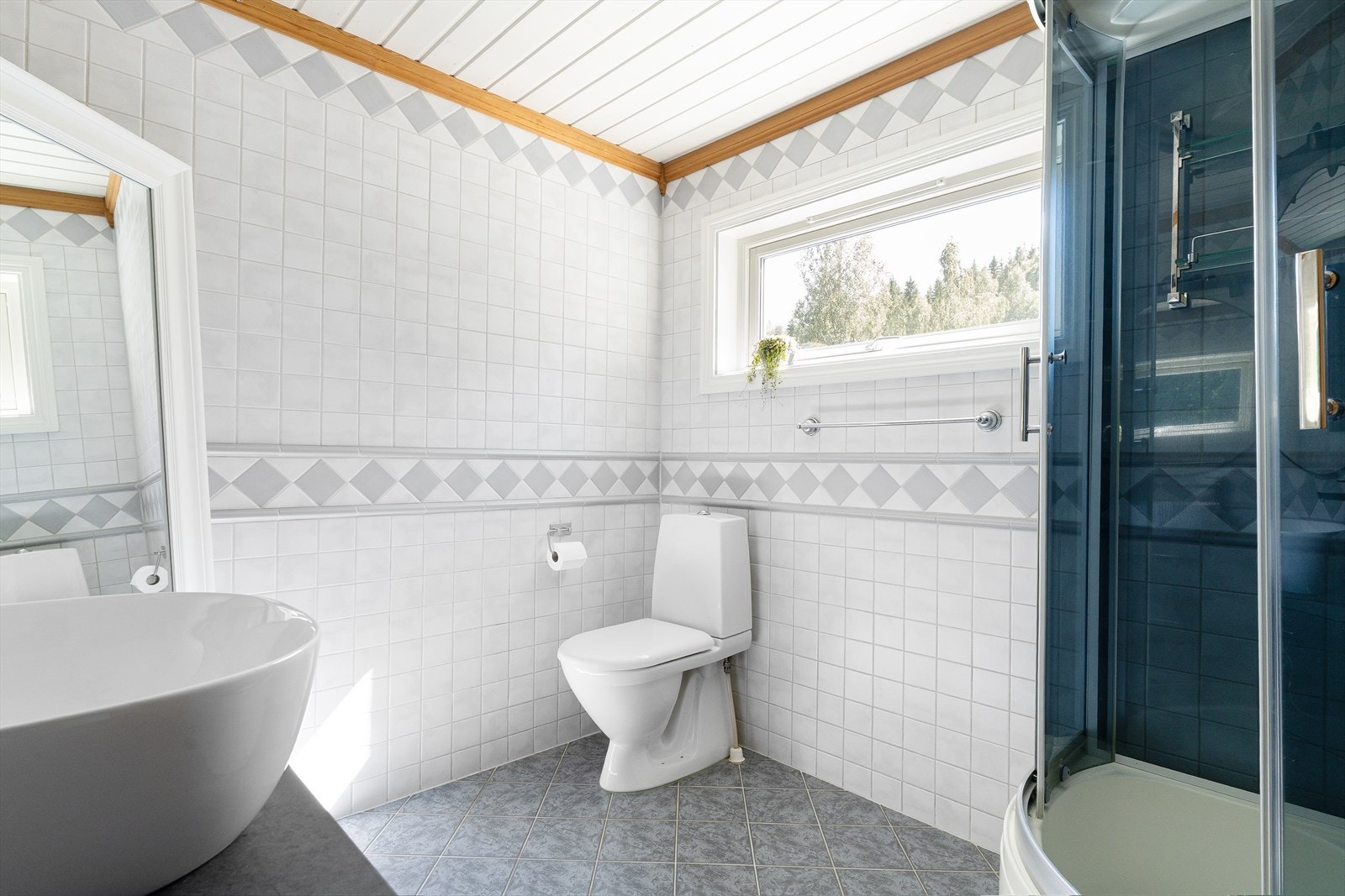 Det er fliser på vegger og gulv med varmekabler i gulvet. Galleribilde