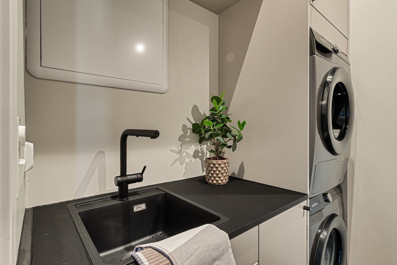 Vaskerommet har en praktisk skap- og benkløsning, med nedfelt utslagsvask, samt opplegg for vaskemaskin og tørketrommel. Galleribilde