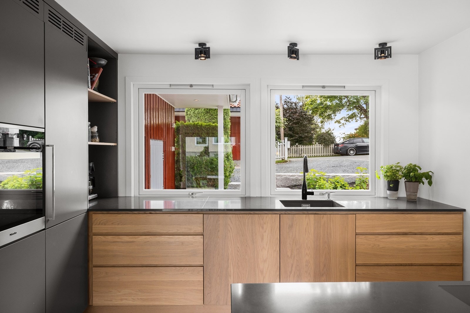 Kjøkkenet er designet med tanke på funsjonalitet og har godt med skap- og benkeplass. Benkeplaten er i kompositt, med underlimt vask fra Blanco og ettgreps kjøkkenarmatur. Galleribilde