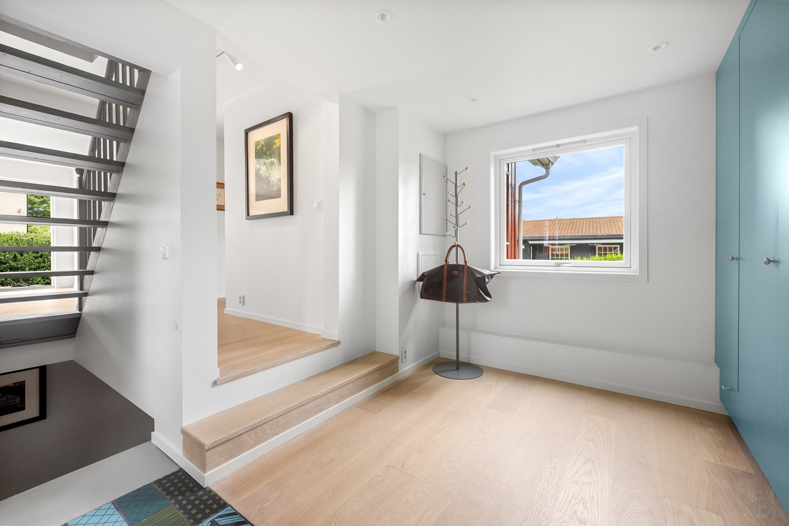 Entreen er lys og luftig med malte slette flater på vegger og i himling samt downlights som lyskilde. Det er lys eikeparkett samt fliser på gulv med varmekabler. Det er montert en romslig garderobe fra Hamran Møbelverksted i entreen. Galleribilde