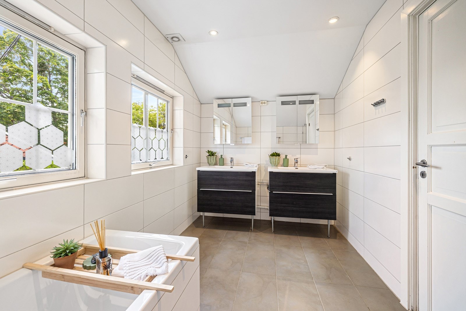 Badet i 2. etasje ble modernisert i 2011 med nytt sluk, membran og nye fliser. Det er 30x60 fliser på vegger og gulv med varmekabler samt malt himling med dimbare spotter. Innredningen består av to skuffeseksjoner med nedfelt servant. Galleribilde