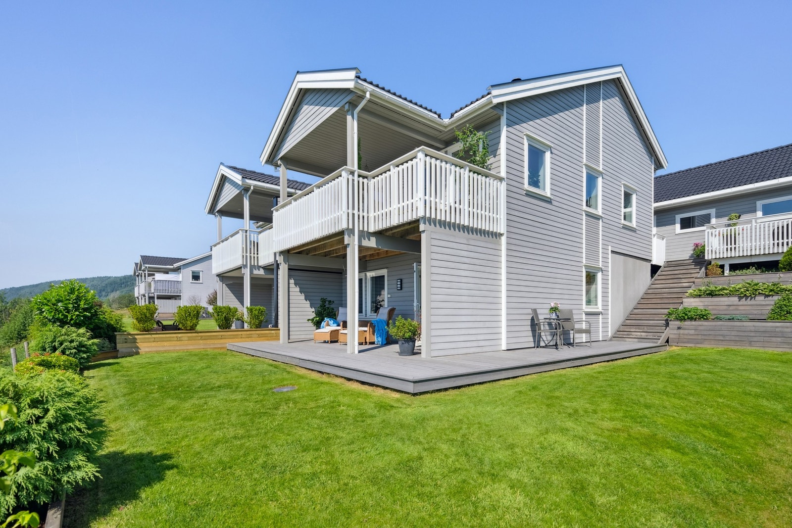 Boligen har et pent opparbeidet uteområde med plen, beplantning samt ulike busker og trær Galleribilde