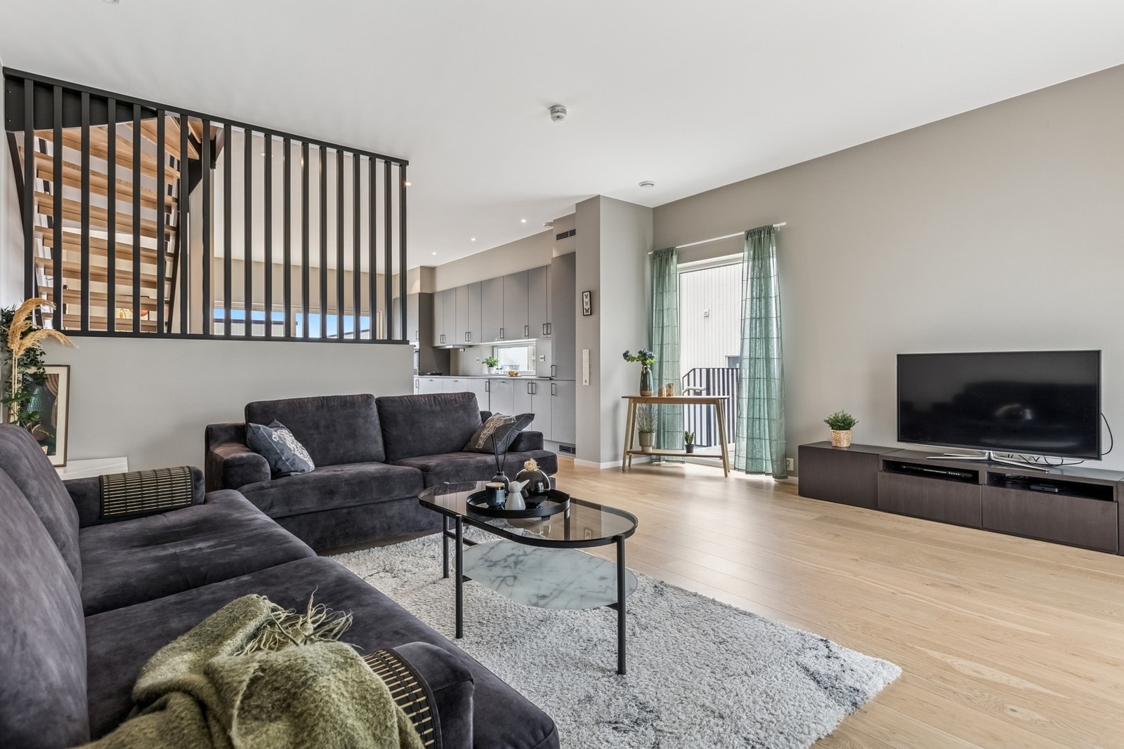 Her er det plass til både sofagruppe, bord og TV-løsning, samtidig som rommet oppleves åpent og funksjonelt. Galleribilde