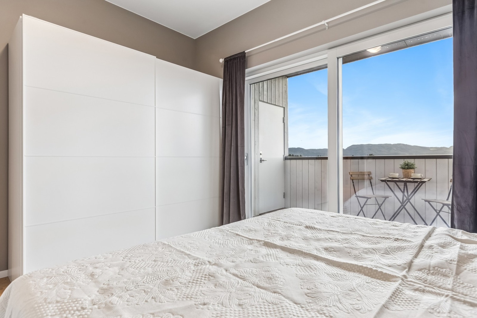 Soverommet har god plass og direkte tilgang til balkong, ideelt for å nyte morgenstunden. Galleribilde
