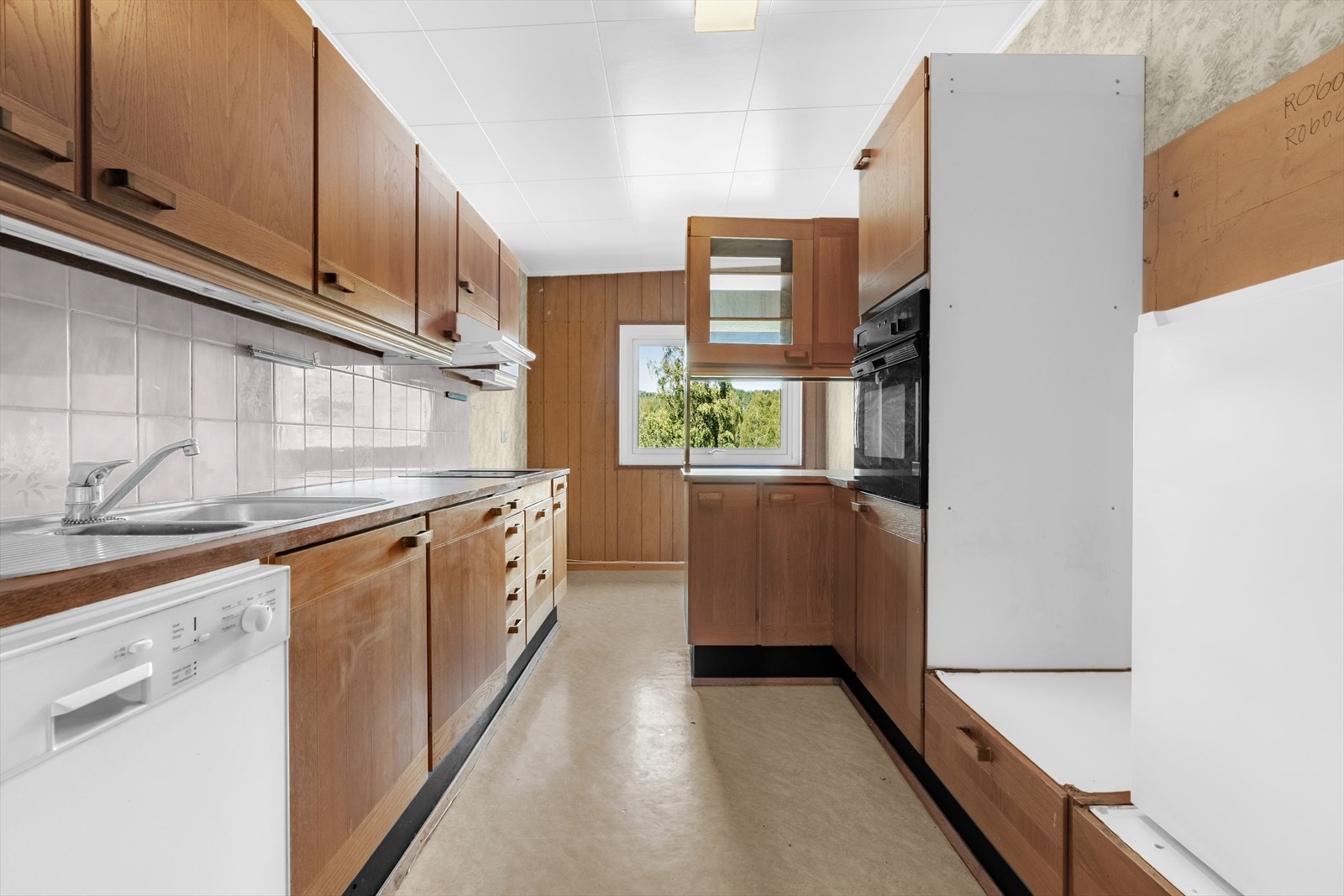 Separat, eldre kjøkken med delvis integrerte hvitevarer. Galleribilde