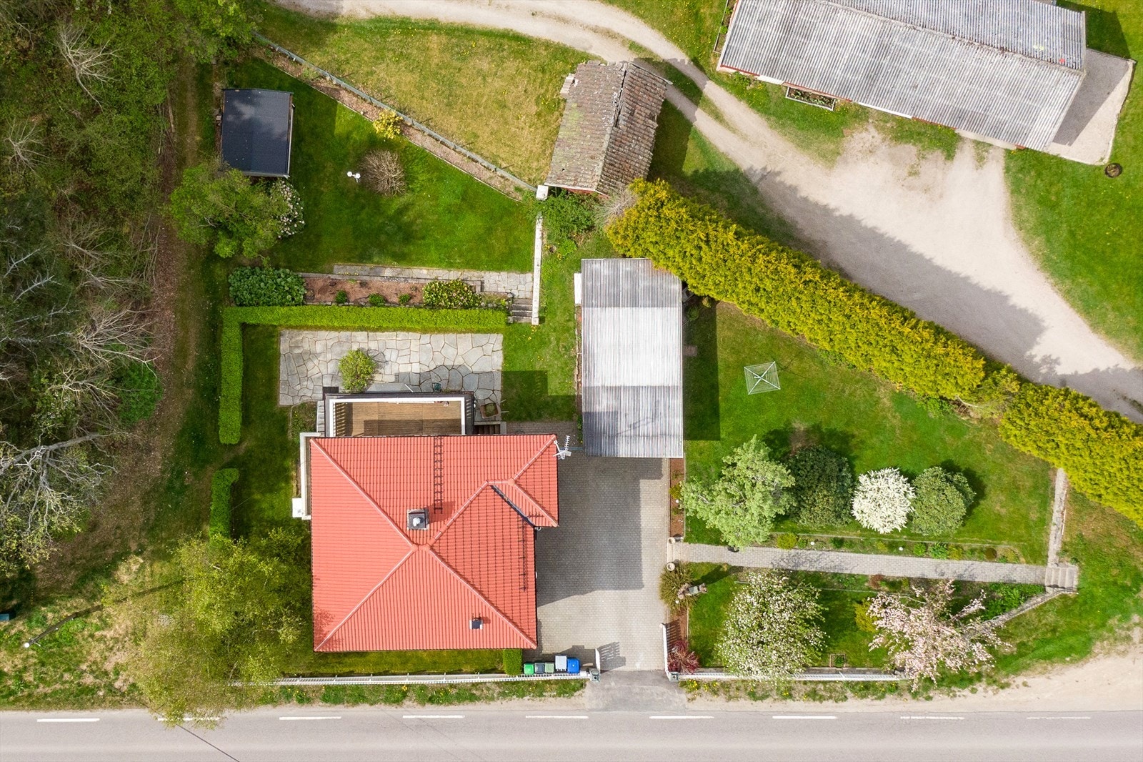 Eiendommen har en triangelformet tomt med opparbeidet hage på flere sider. Galleribilde