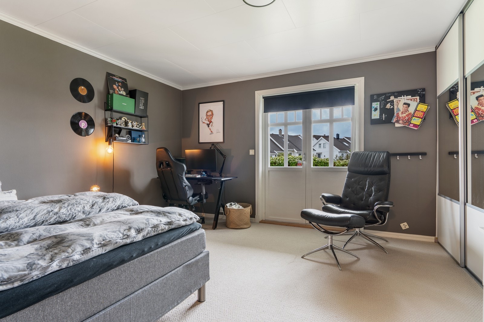 Stort soverom i første etasje med skyvedørsgarderobe, teppe på gulv og utgang til hagen/uteområdet. Galleribilde