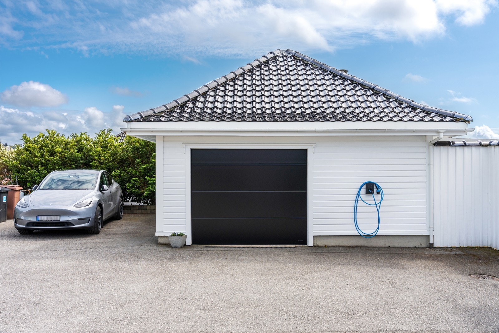 Garasje med el-bil lader. Porten er nyere. Oppbevaring på loft. Galleribilde