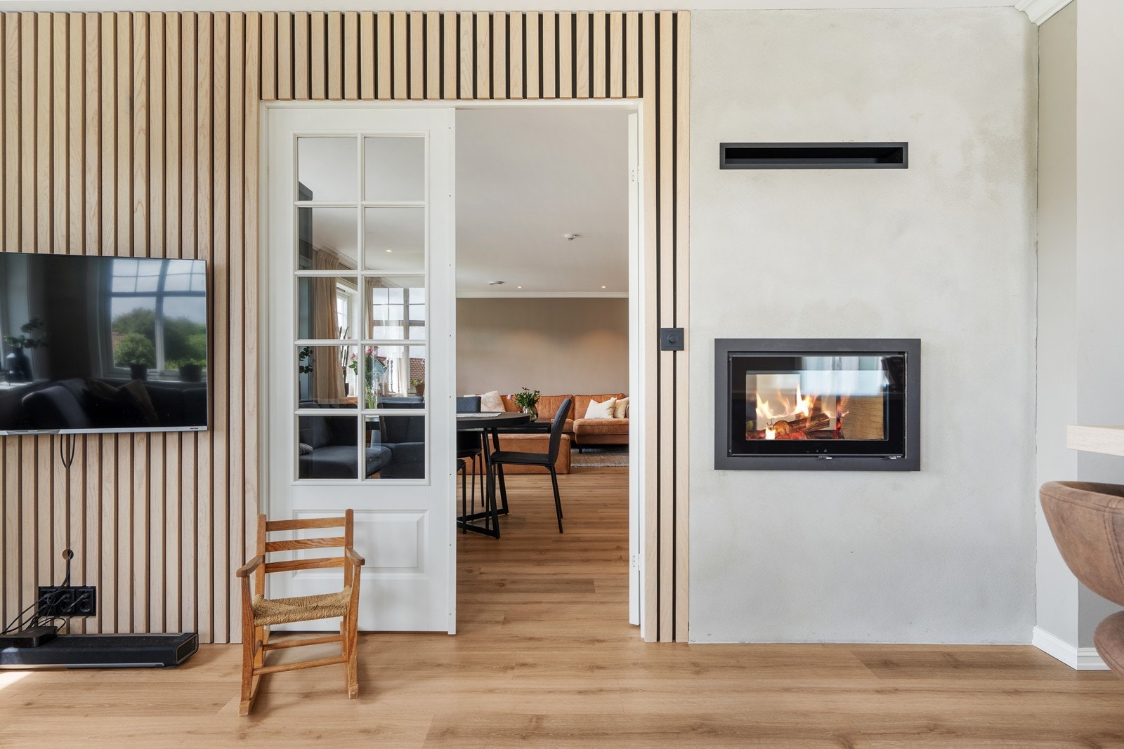 Lekre detaljer med heltre eikespiler, to-fløyet fransk dør med glassfelt og en tosidig kvalitets vedovn i merket Rais. Galleribilde