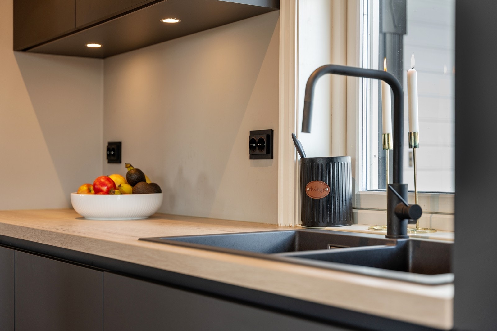 Downligts under overskap og sorte detaljer på stikkontakter og brytere. Galleribilde