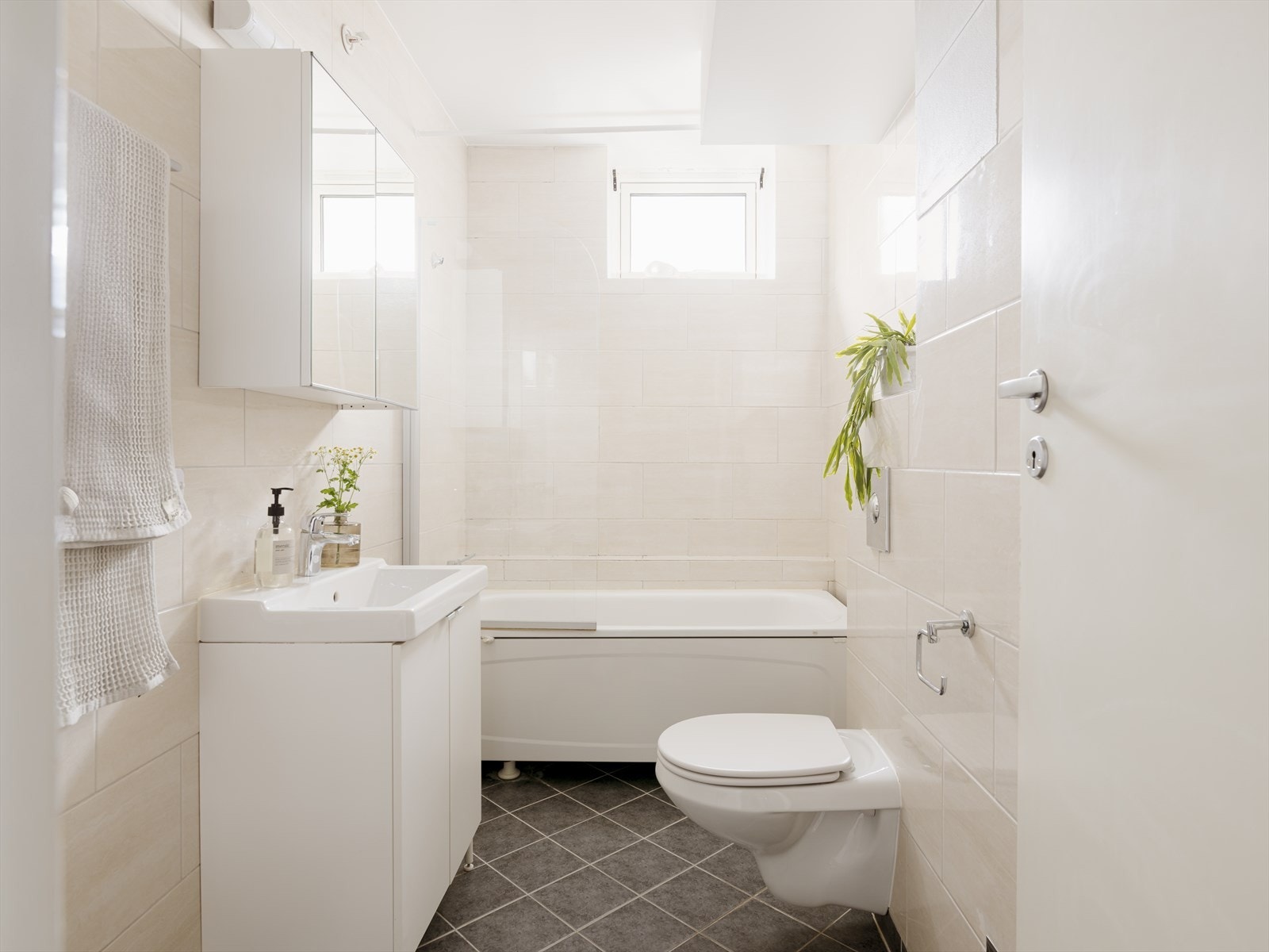 Lyst og innbydende baderom med flislagt overflater i en tidsnøytral utførelse. Galleribilde