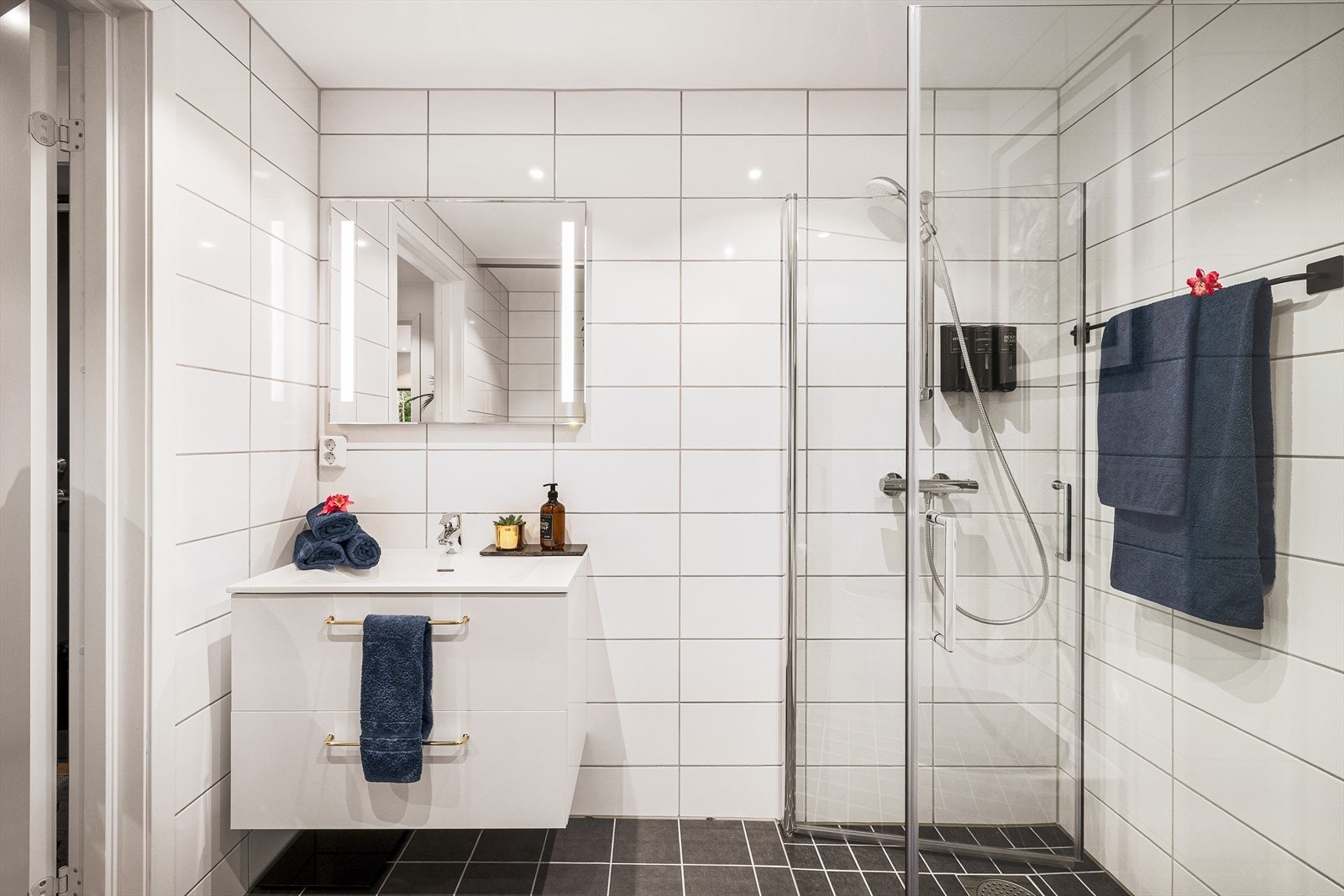 Dimmbare spotter på bad. Rommet har innredning med nedfelt servant, veggmontert toalett, dusjvegger/hjørne og opplegg for vaskemaskin. Balansert ventilasjon. Galleribilde