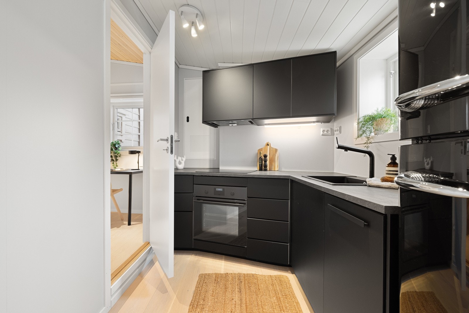 Integrerte hvitevarer som stekeovn, induksjonstopp, oppvaskmaskin (smal modell) og integrert ventilator Galleribilde