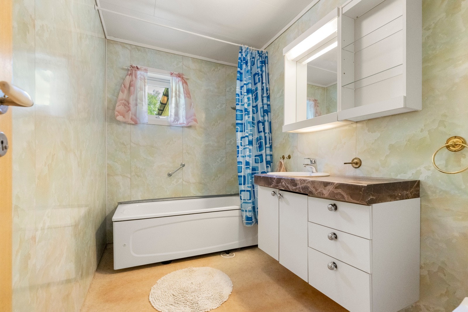 Bad med varmekabler i gulv. Innredet med nedfelt servant m/underskap, klosett, badekar og veggmontert dusjgarnityr. Galleribilde