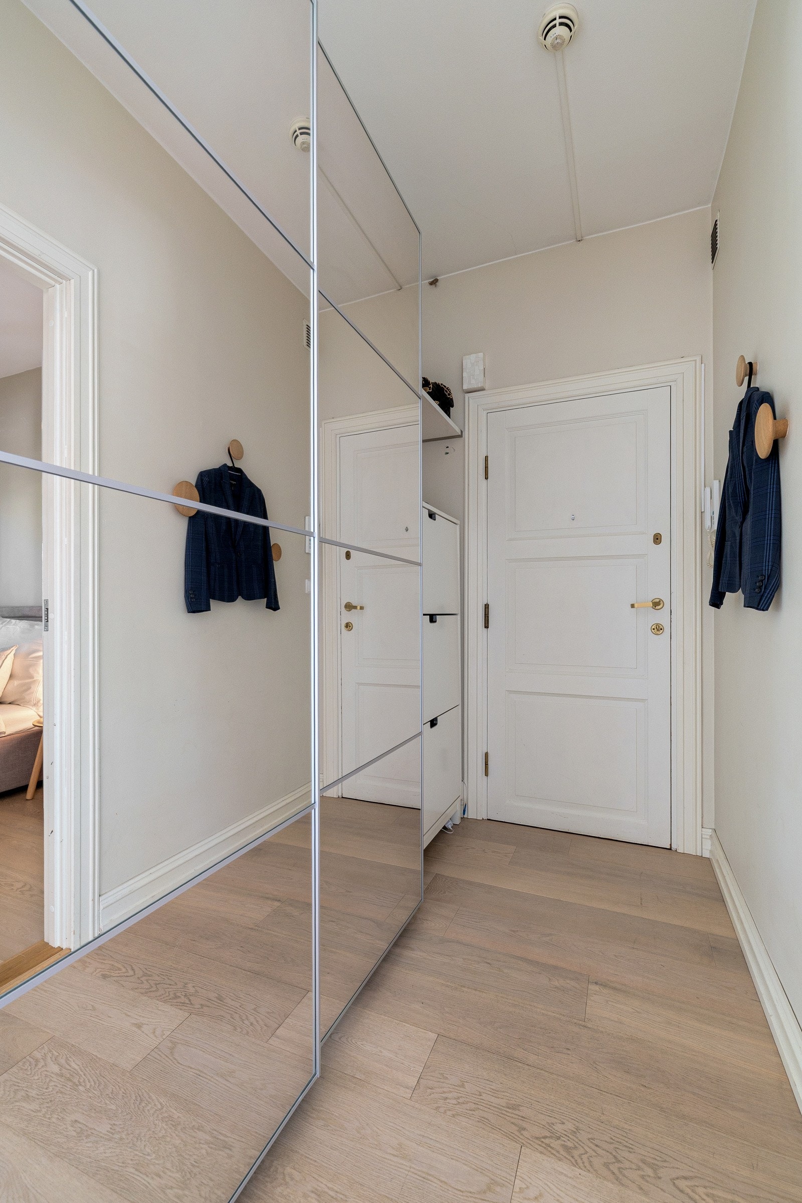 Entréen er romslig og gir et godt førsteinntrykk av leiligheten. Her er det rikelig med plass til oppbevaring av yttertøy og sko, og dørcalling gjør det enkelt å slippe inn gjester direkte fra bakkeplan. Galleribilde