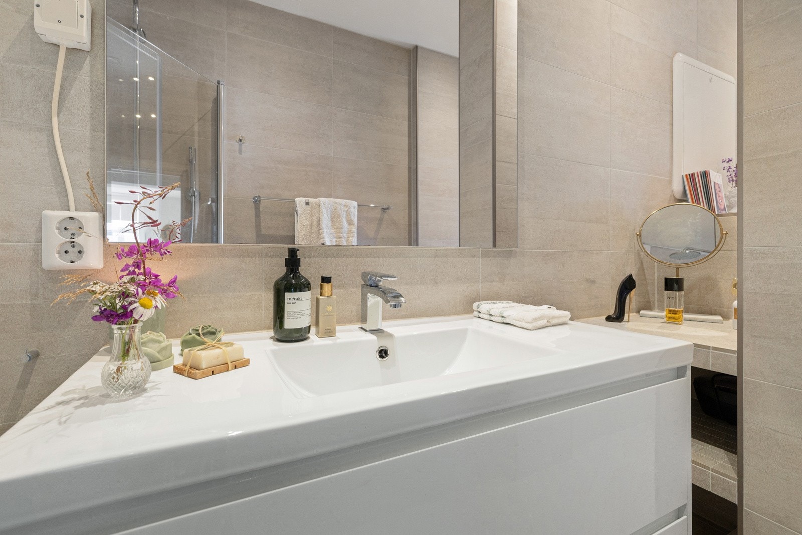 Badet er innredet med vegghengt toalett, dusjnisje, servant og opplegg for vaskemaskin. Galleribilde