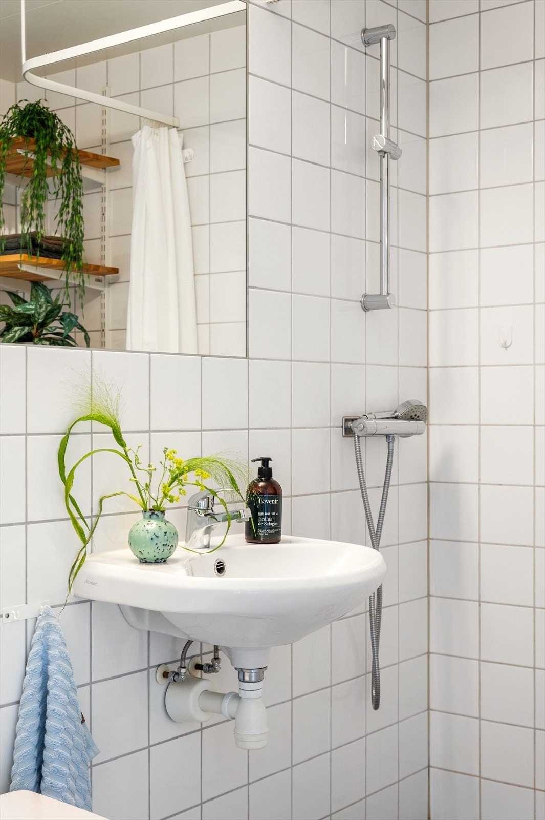 Badet er utstyrt med dusjhjørne, vegghengt servant, stort speil og vegghengt toalett. Galleribilde