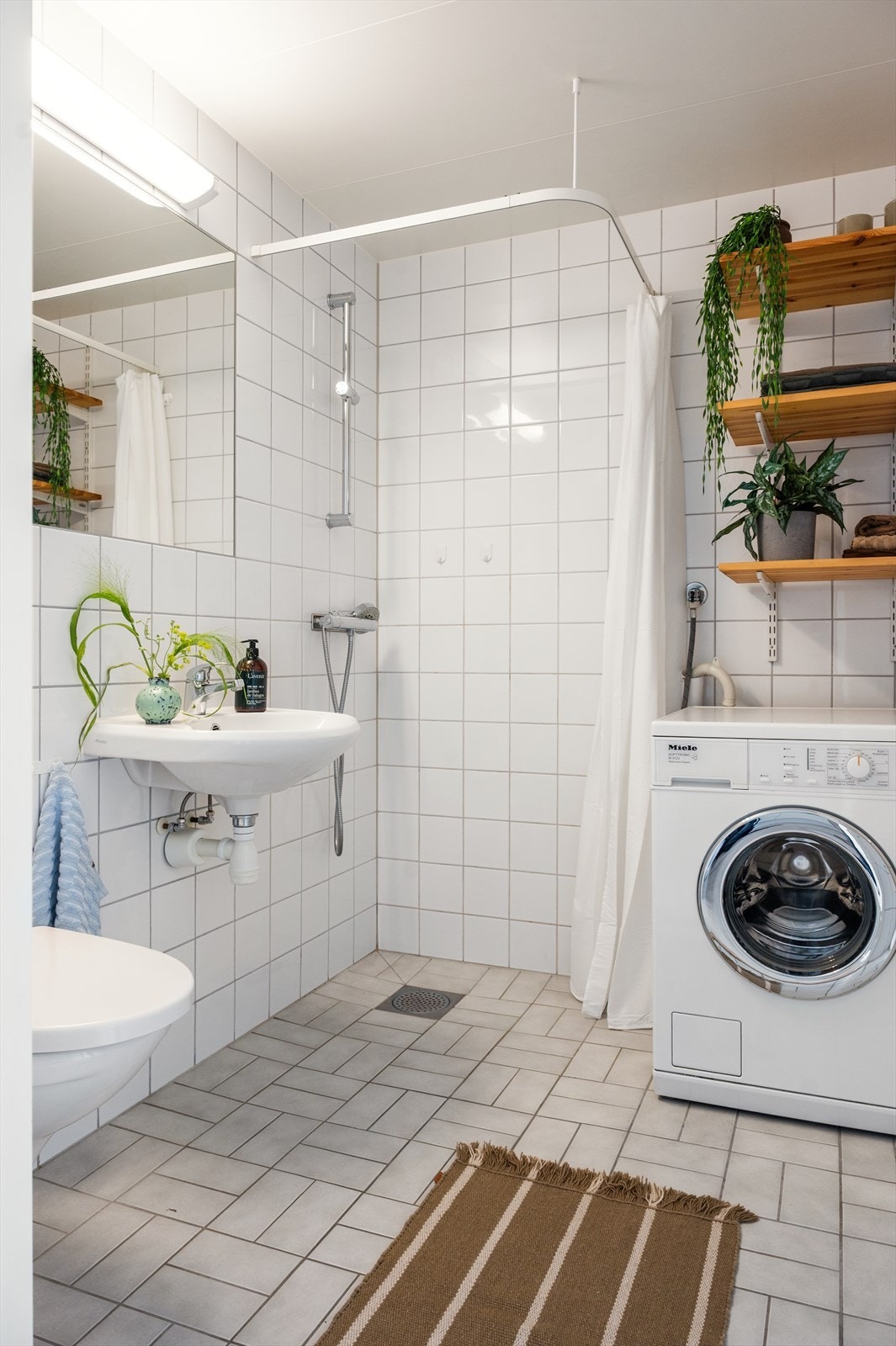 Videre er det opplegg for vaskemaskin og praktiske hyller på vegg. Galleribilde