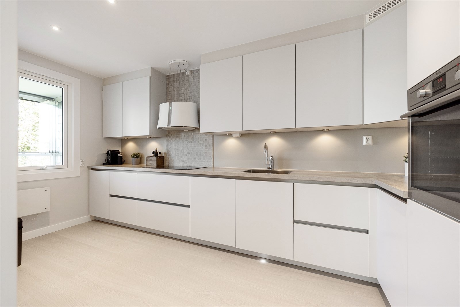 Lys innredning med glatte fronter og benkeplate i laminat. Galleribilde