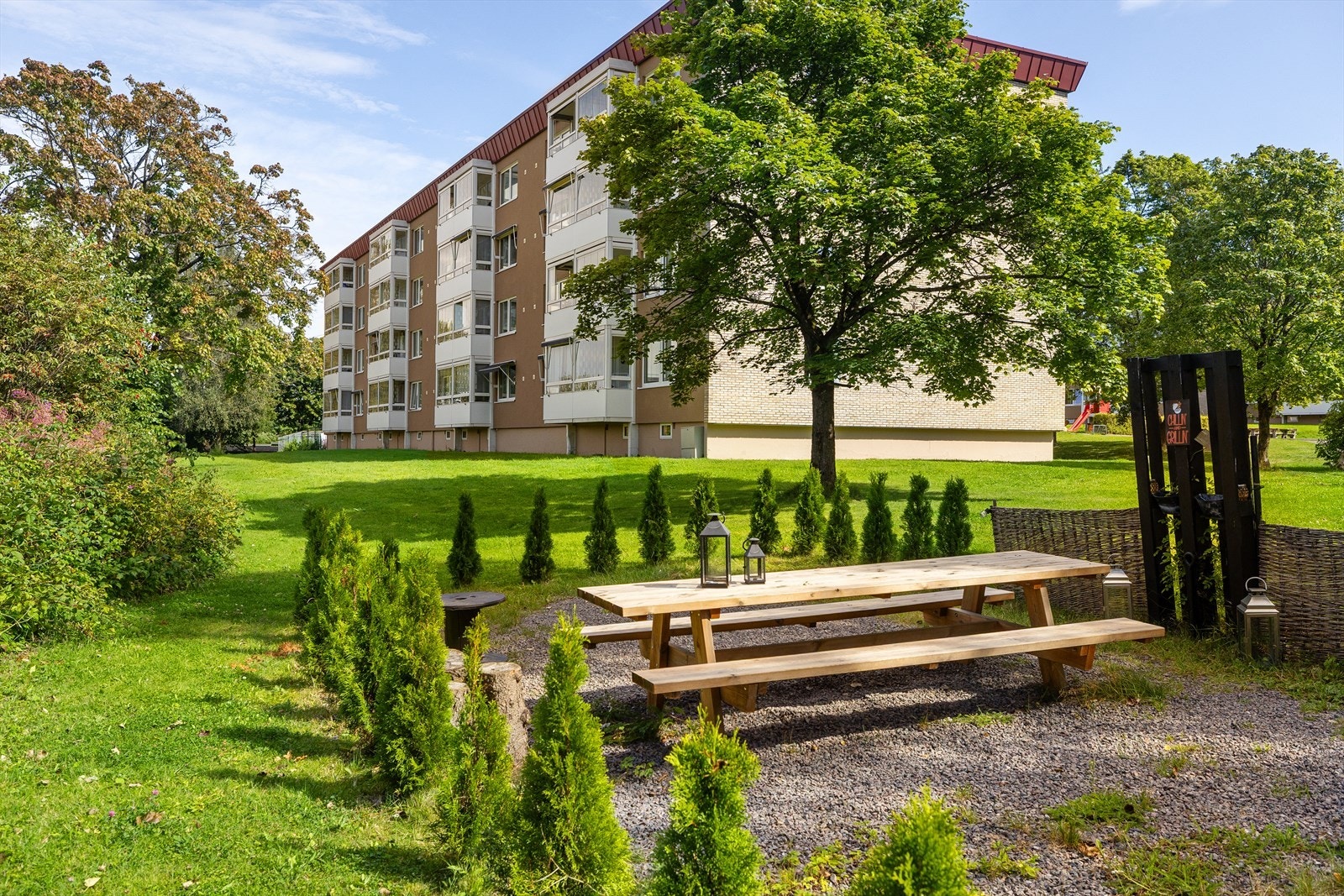 Borettslaget har en stor uteplass med plen og beplantning. Galleribilde