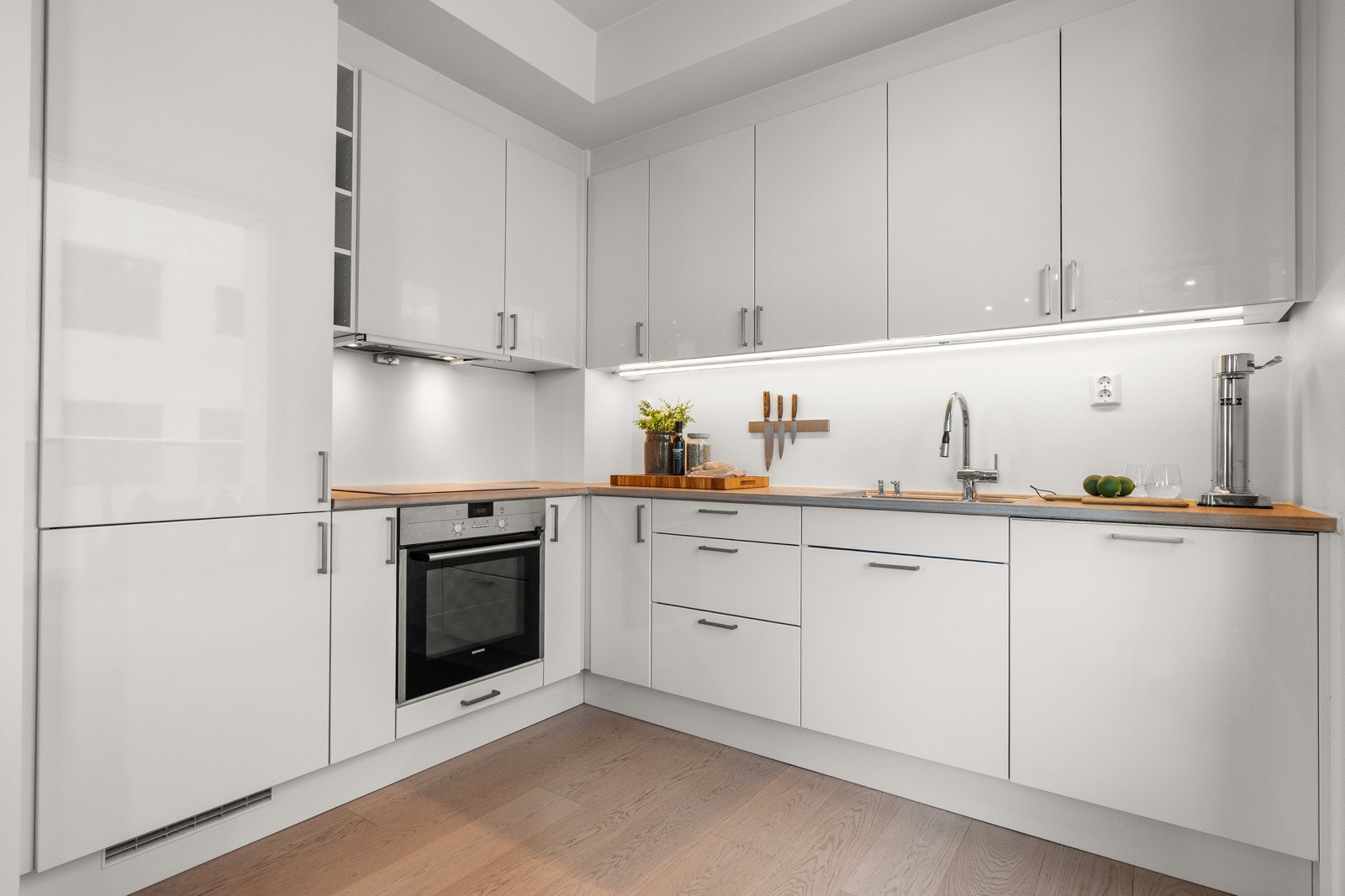 Innredningen har glatte fronter, benkeplate av tre, nedfelt oppvaskkum med ett-greps kjøkkenarmatur samt benkeskapsbelysning og stikkontakt over kjøkkenbenk. Galleribilde