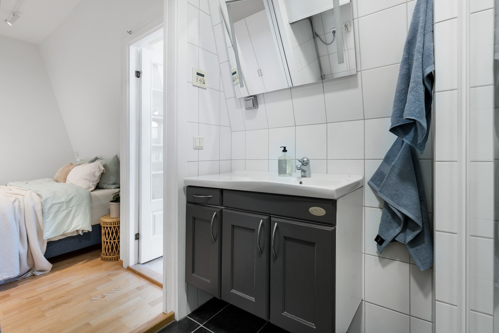 Baderommet i boligen er flislagt med keramiske fliser på gulv og vegger i hvite og sorte farger. Galleribilde