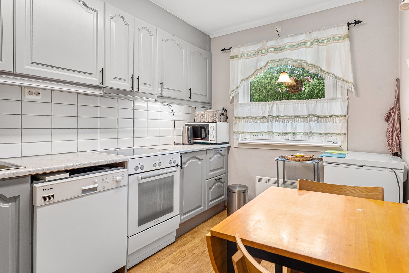 Kjøkkenet har godt med skap og benkplass Galleribilde