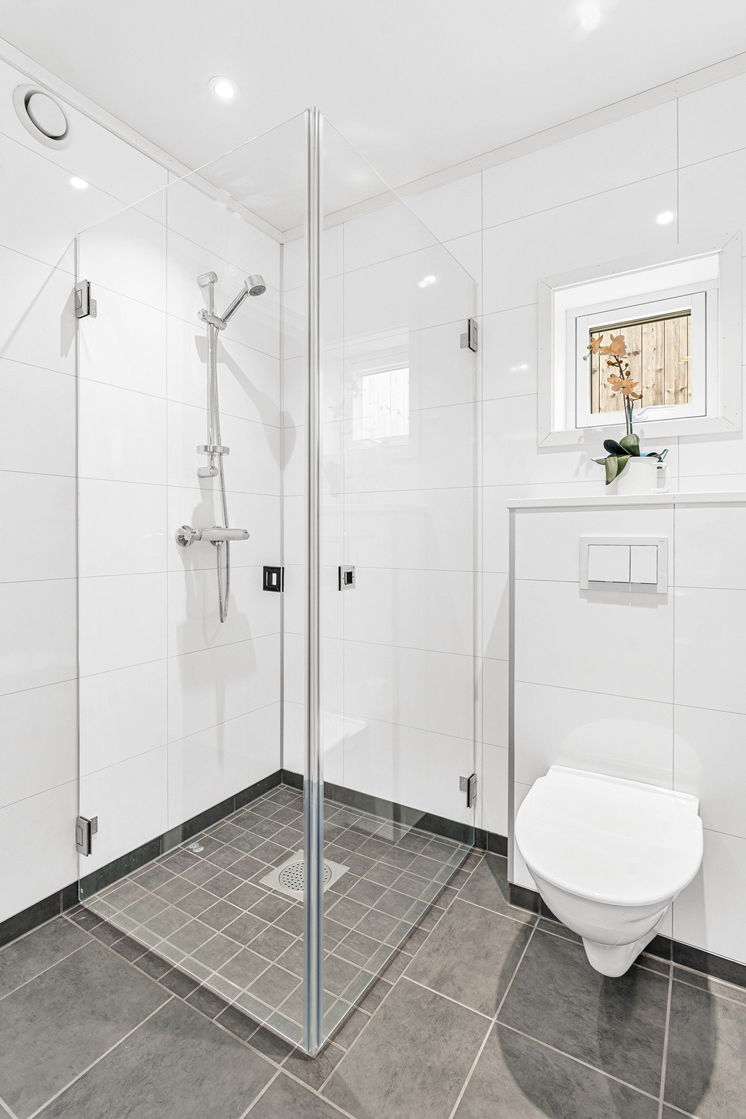 Badet har dusjhjørne og vegghengt toalett. Galleribilde