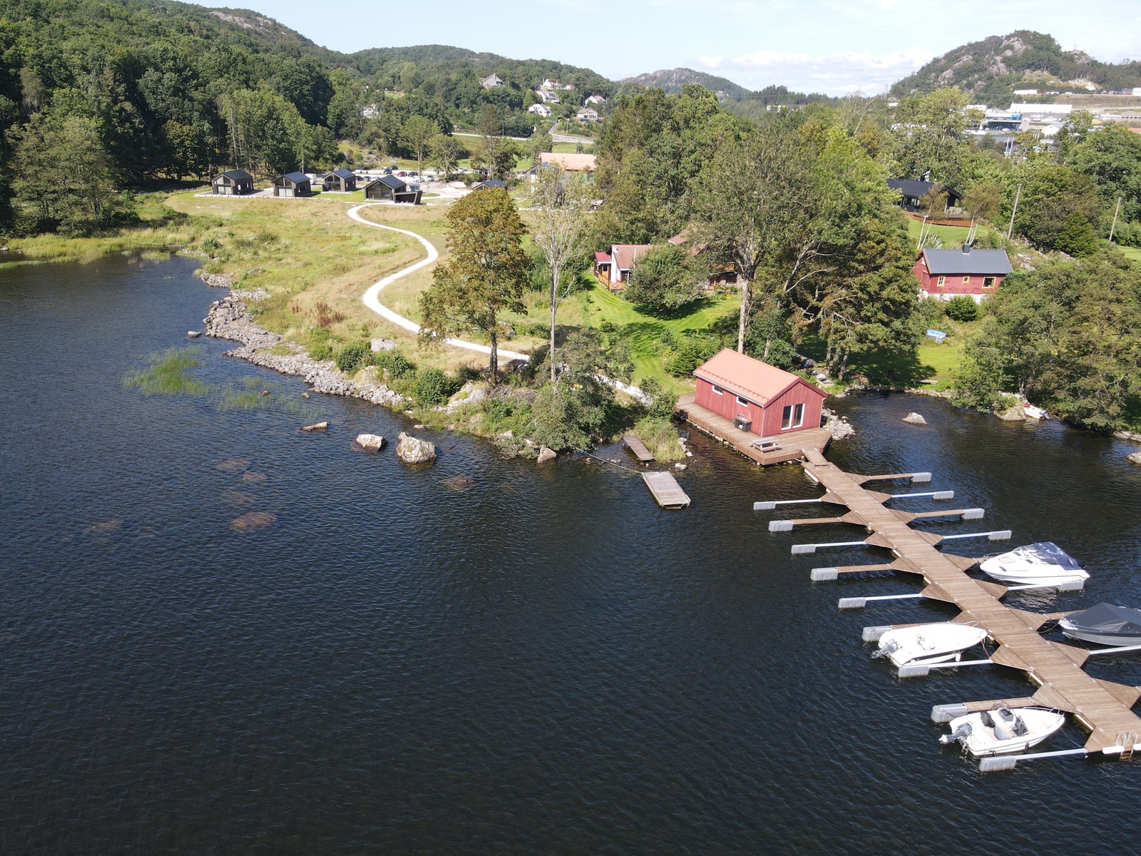 Båtplass og sjøbu med hyttefeltet i bakgrunnebn Galleribilde