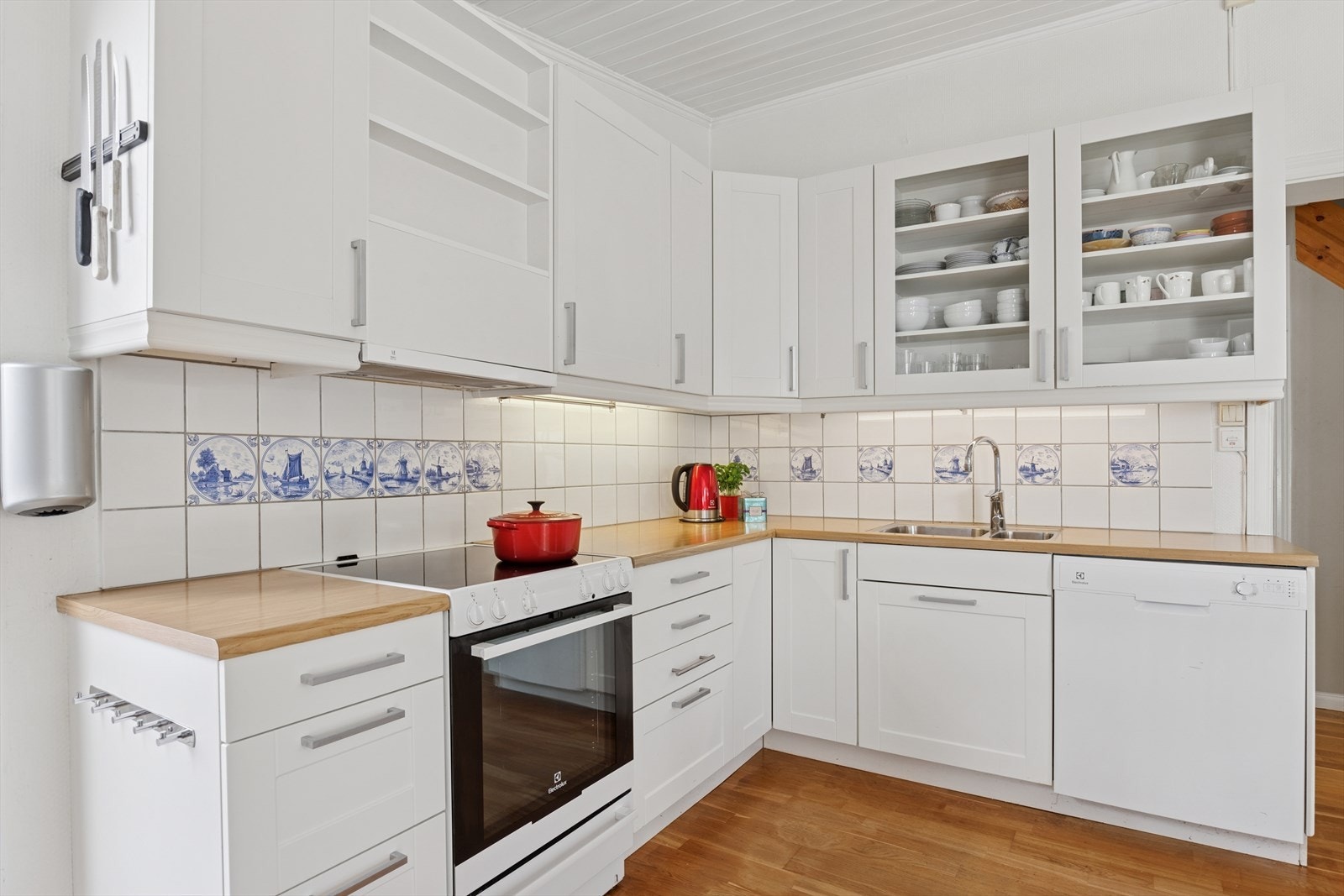 Veggene er tapetserte med fliser mellom over- og underskap, noe som gir et moderne og praktisk preg. Himlingen er med malt panel, som gir en lys og luftig følelse. Galleribilde