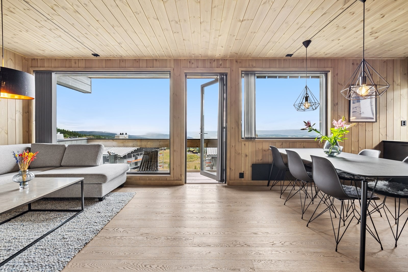 Den åpne løsningen gir god flyt mellom kjøkken og stue, og store vinduer slipper inn rikelig med lys Galleribilde