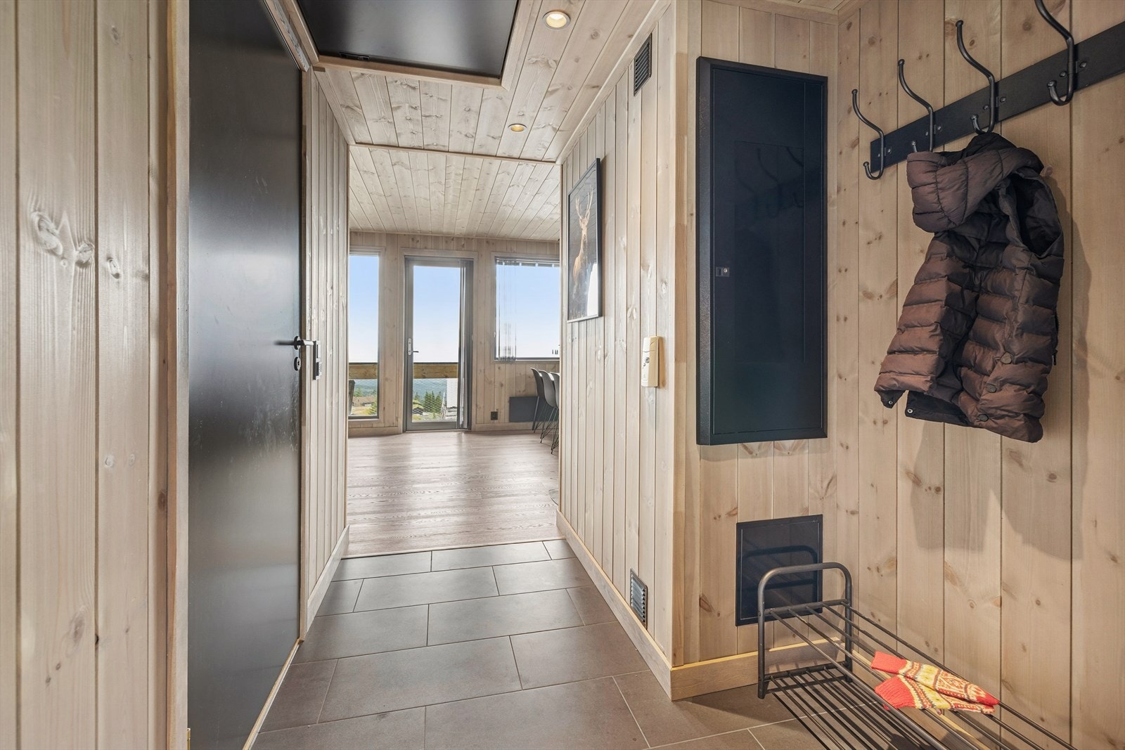 Her ønskes du velkommen inn et vindfang med plass til å henge fra deg ytterklær, og sko. Velkommen inn! Galleribilde