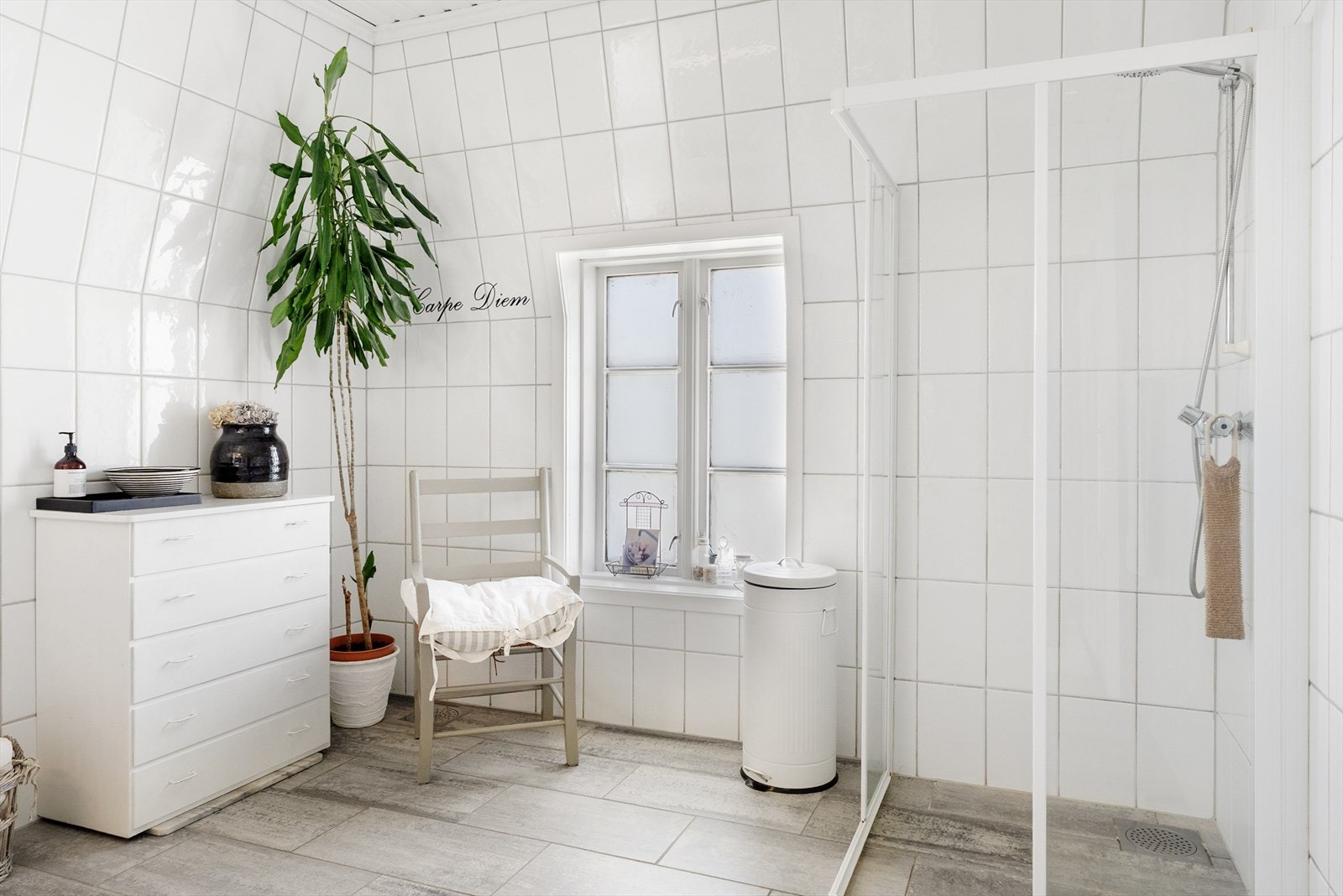 Luftig baderom som inneholder dusjhjørne, toalett og skapinnredning med servant. Galleribilde