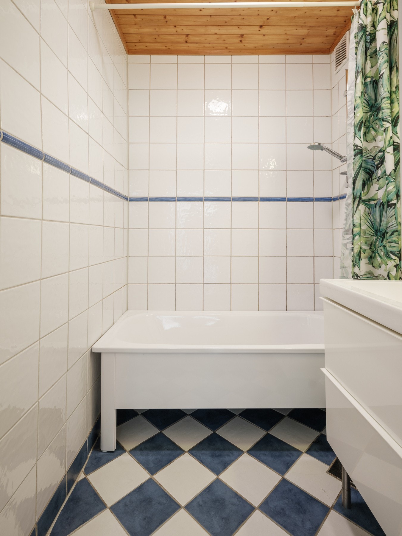 Helfliset bad innredet med vegghengt og gulvstående servantskap med skuffer, ovenpåliggende servant, speil og overbelysning med stikkontakt på vegg over servant, samt frittstående badekar. Galleribilde