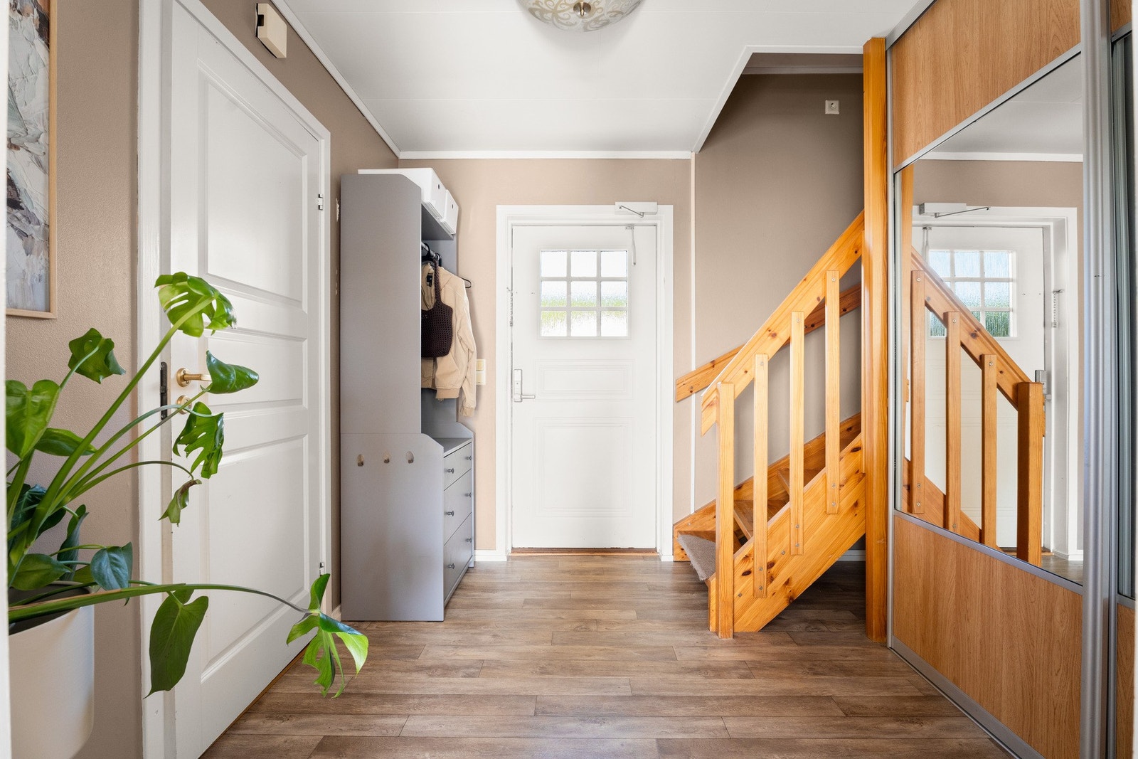 Veggene i entreen er malt i en delikat beigetone, og det er belegg i parkettimitasjon på gulv med vannbåren gulvvarme - en komfortdetalj som er gjennomgående for hele første etasje. Galleribilde