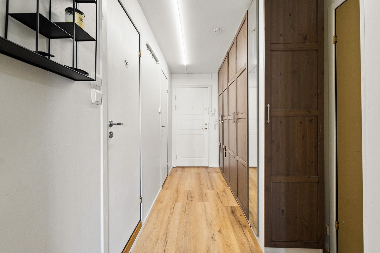 Innbydende entré med praktiske garderobeløsninger som gir rikelig oppbevaringsplass til klær og sko. Galleribilde