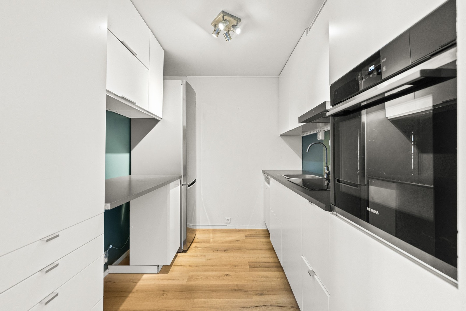 Kjøkkenet er innredet med rene linjer og rikelig med skapplass - en funksjonell løsning for den matglade. Galleribilde