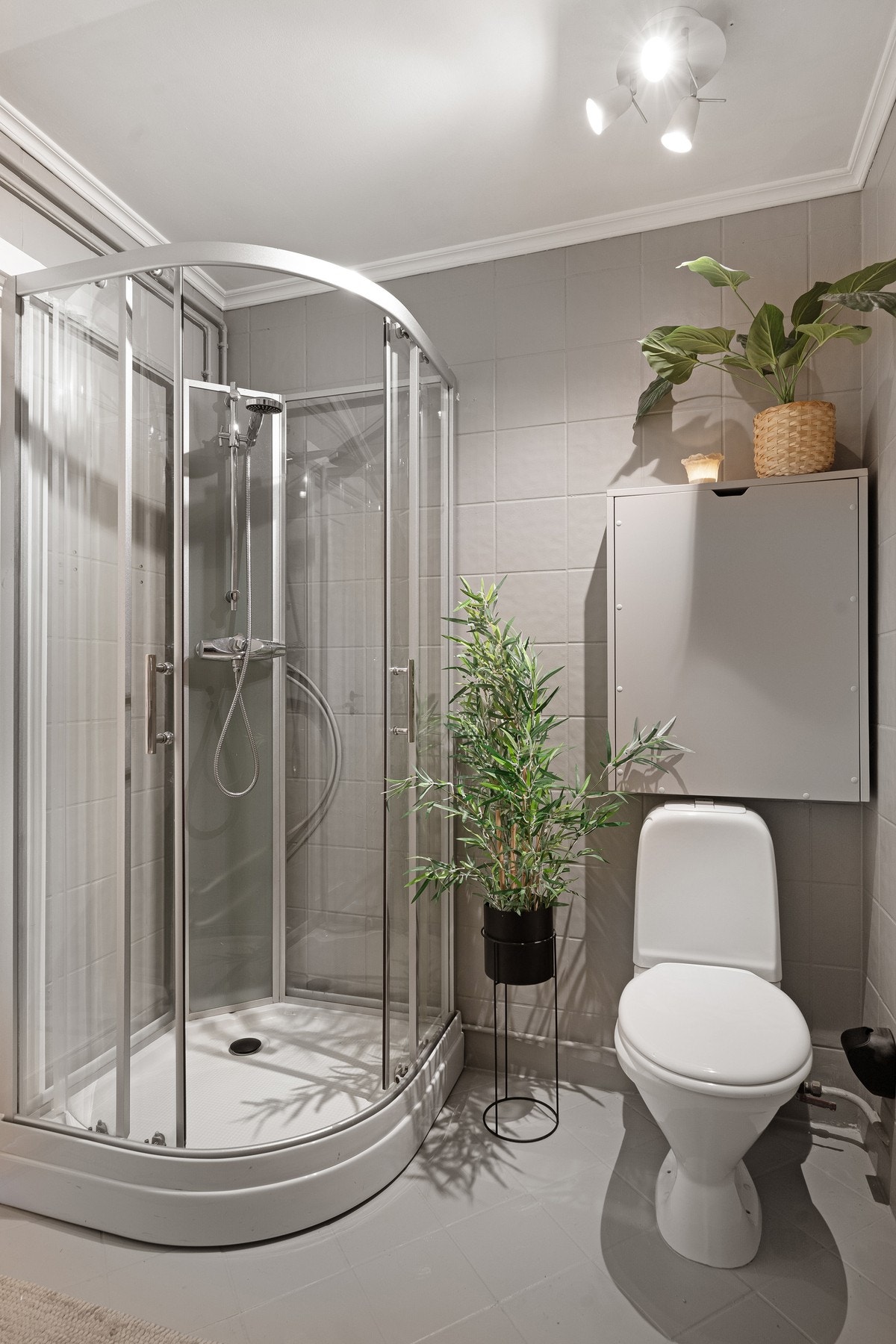 Flislagt bad med dusjkabinett, toalett og nedfelt servant. Galleribilde