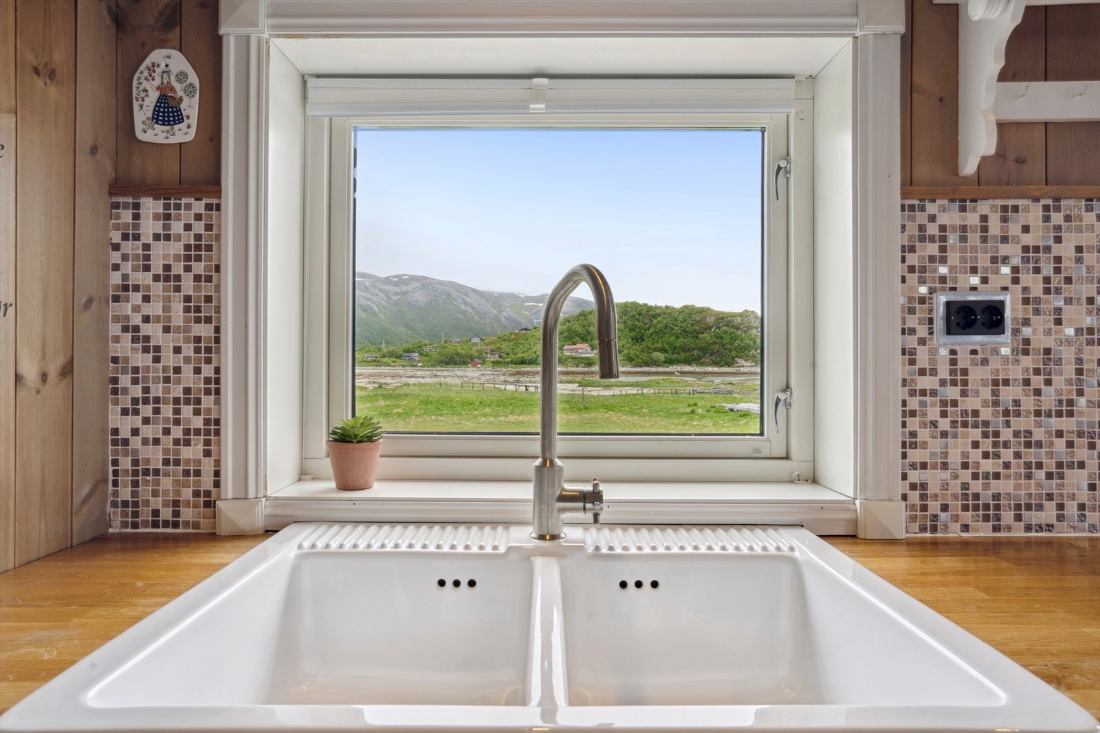 Det er lagt mosaikkfliser på vegg over benkeplaten. Galleribilde