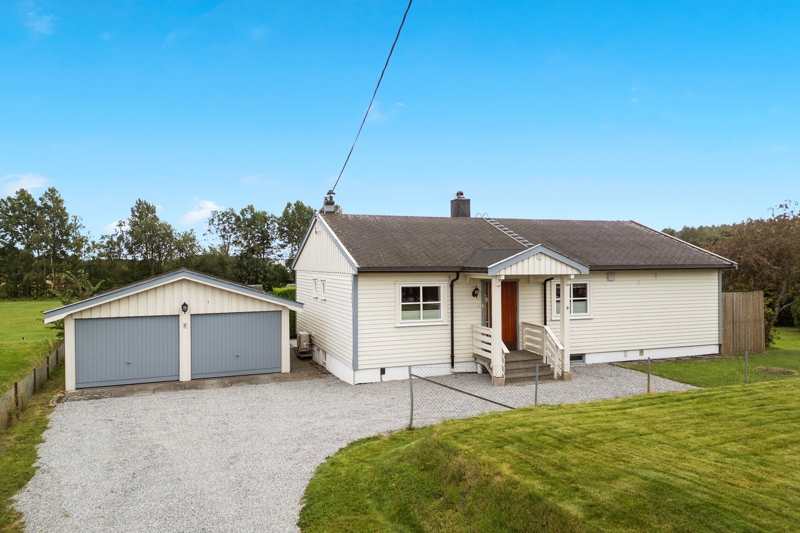 Pent og ryddig adkomstparti med gruset innkjørsel og en dobbelgarasje på 48m². Galleribilde