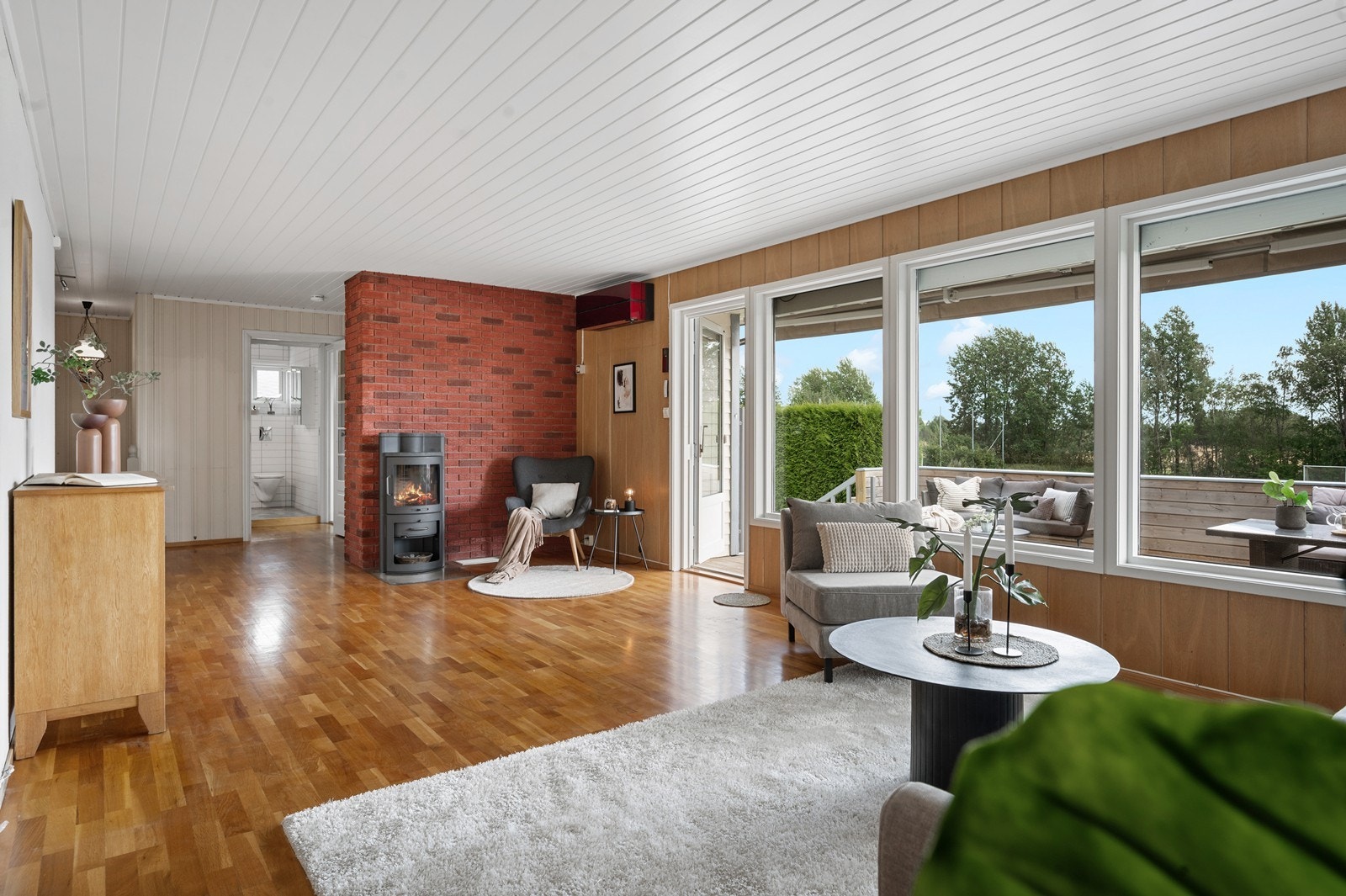 En sjarmerende vedovn skaper en lun og hyggelig atmosfære i stuen. Det er også montert en varmepumpe i stuen. Galleribilde