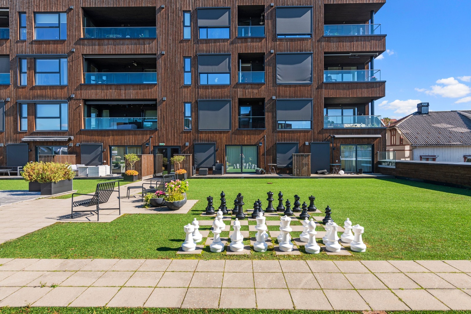 I atriet, en trapp ned fra leiligheten, finner du en stor takterrasse med med lekeapparater for barna, koselig beplantning og sittegrupper som innbyr til avslapning og sosialt samvær. Galleribilde