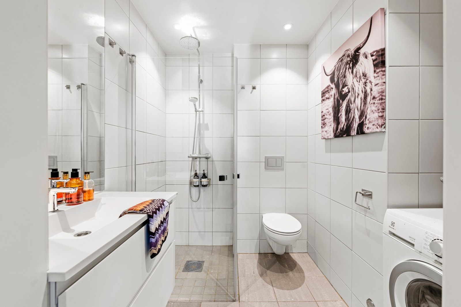 Leiligheten har et flott og lyst bad levert av utbygger. Rommet inneholder innredning, servant, vegghengt wc, opplegg for vaskemaskin og dusjhjørne. Galleribilde